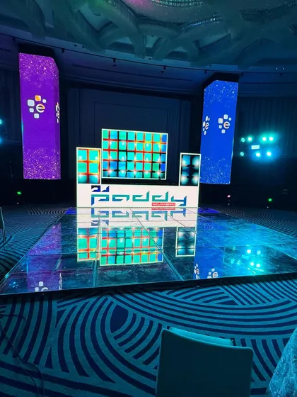 A wide shot of my corporate event setup, showing the main DJ booth, LED floor, and large vertical LED pillars for a complete visual package.