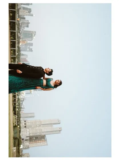 An artistic and unconventional portrait of Radhika and Shyam with the city skyline. The rotated perspective creates a surreal, eye-catching image that plays with gravity and urban landscapes.