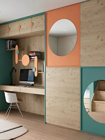 This playful and modern kid's room features our custom woodwork with a mix of natural wood tones, teal, and orange accents. The design includes a fully integrated study desk, overhead cabinets, and a unique wall unit with circular mirrors and cutouts that add a touch of whimsy while remaining practical.