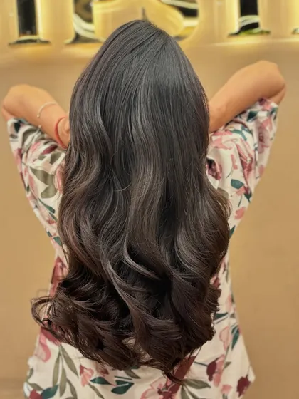 The back of a client's hair after a fresh haircut, styled with soft waves to show off the new layers and healthy ends.