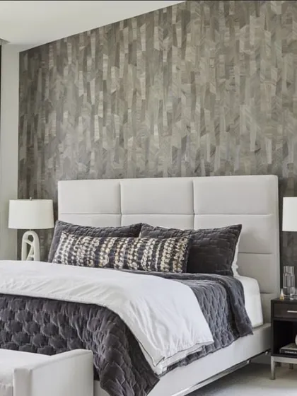 A modern bedroom featuring Phillip Jeffries’ authentic wood veneer wallcovering, Sculpted Wood. The vertical grain and varied tones add natural texture and a sense of height to the serene space.