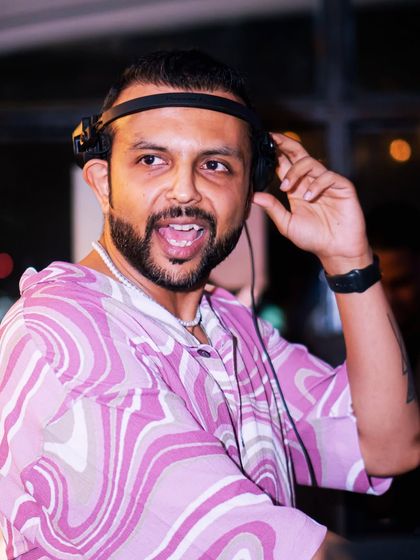 A close-up shot, headphones on, ready to mix. The focus is intense, but the vibe is all fun.