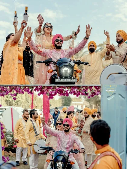 The groom makes a cool entry on a motorcycle with the bride riding pillion, a unique and fun start to their Haldi ceremony.