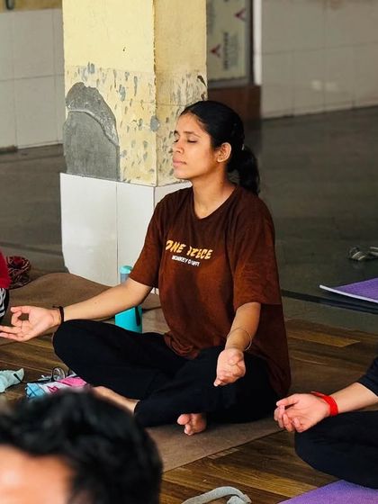 Three students are seen here in a state of deep meditation. Their calm expressions show the peace that comes from focusing inward.
