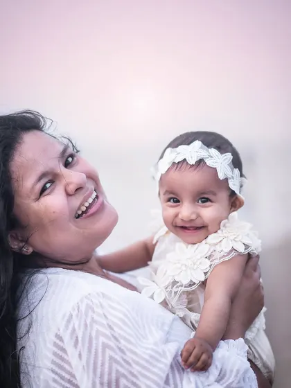 A beautiful, happy portrait of a mother and her baby girl at the beach. The genuine smiles and soft sunset light make this a truly precious memory.