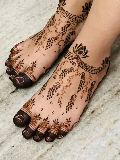 My feet designs are all about elegance. This piece features delicate peacock and grape-vine trails, flowing from a lotus anklet band, creating a graceful and light look.