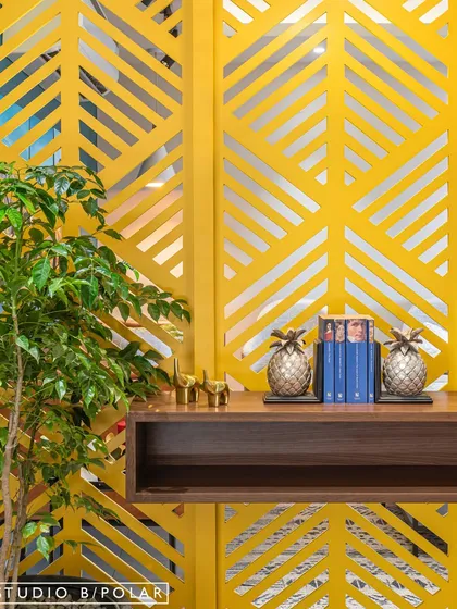 A detail from an early project where we fully embraced color. A bright yellow laser-cut partition with a leaf motif serves as a functional art piece, separating spaces while adding a joyful, graphic element.