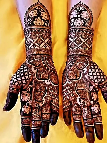 A stunning example of negative space design, where the skin forms part of the pattern. The bold, dark henna makes the lotus motifs pop.