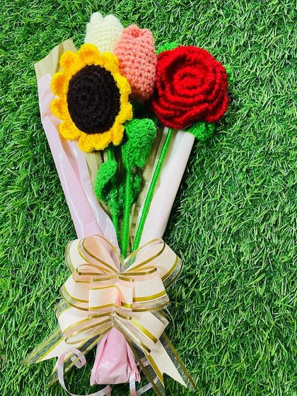 This popular crochet bouquet is a wonderful gift, featuring a sunflower, rose, and tulips tied with a beautiful bow. It's a gift that truly lasts.