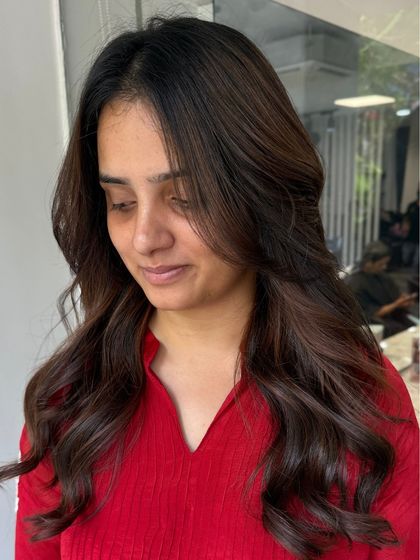A client enjoying her fresh style. The soft waves and face-framing pieces create a flattering and timeless look.