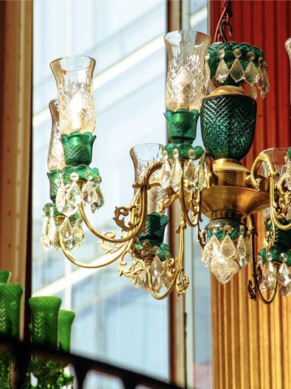 A close-up of our emerald and crystal chandelier. This piece is a testament to our passion for storytelling through design, transforming our space into a living gallery of art and craft.