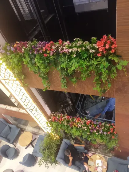 A wider view of the multi-level mall installation, adding color and life to the building's interior architecture.