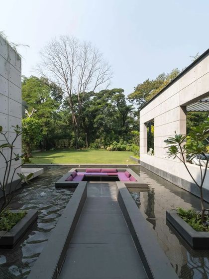 A sunken seating area is set within the water body, offering a unique and immersive place for conversation and relaxation.