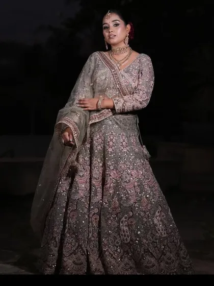 A full-length pose in the grey and pink lehenga, showcasing the detailed paisley embroidery on the skirt.