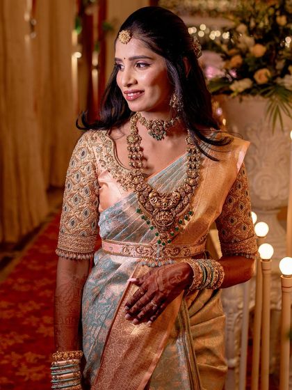 A full-length view of the bride, her pastel saree looking elegant and sophisticated.