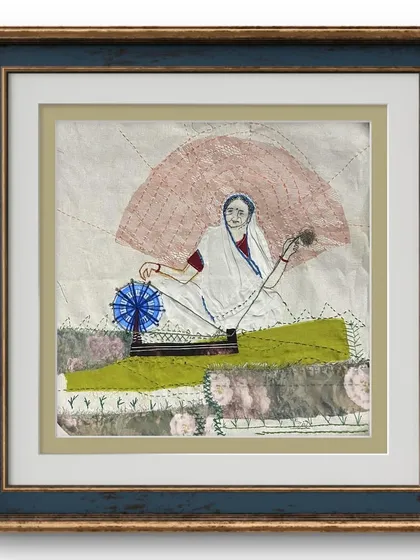 This framed piece is an example of my textile story art. Using scraps of fabric and different colored threads, I've "drawn" a scene of a woman with her charkha, creating a textured artwork that celebrates heritage and craft.