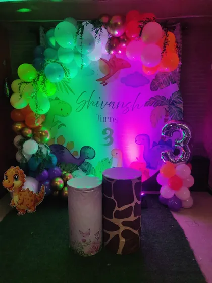The same dinosaur theme, but this time under colorful party lights. This shows how the decor can be transformed with different lighting to create a fun, disco-like atmosphere for the kids.