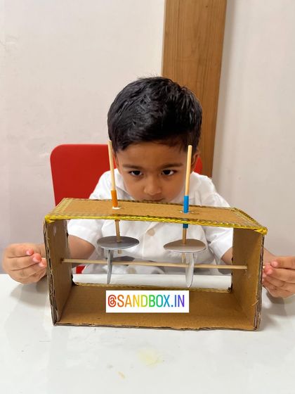 With intense focus, this child works on his simple machine. Each project is a puzzle that teaches patience, precision, and the satisfaction of building something that works.