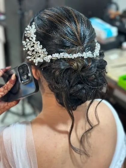 A still shot of the intricate bridal bun, showing the texture and placement of the hair accessory. This is a popular style for modern brides.