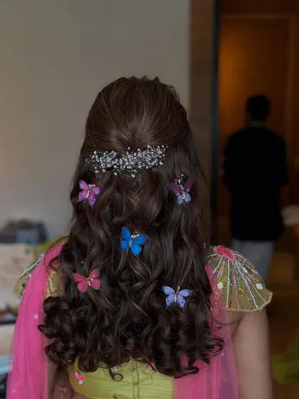 A close-up of the butterfly-themed Mehndi hairstyle, showing the delicate silver accessory at the top.