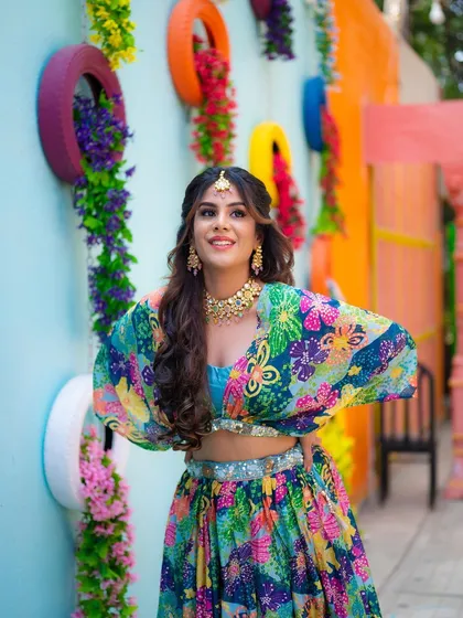 The Mehendi ceremony is full of life and color. I captured this bride's vibrant energy and stunning floral lehenga against a festive, colorful background, reflecting the joy of the occasion.