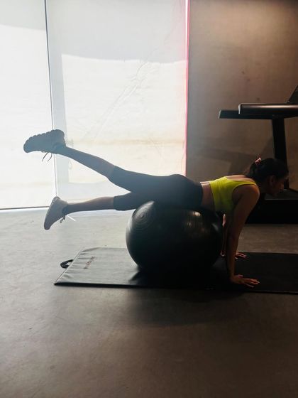 This exercise on the stability ball involves a single leg lift from a prone position. It's excellent for strengthening the glutes and hamstrings while simultaneously engaging the core to prevent the ball from rolling.