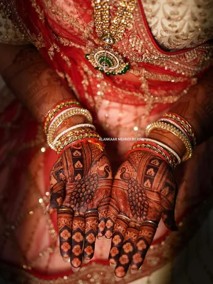 The final look for a bride, with her hands adorned with intricate mehndi that has matured into a deep, dark stain.