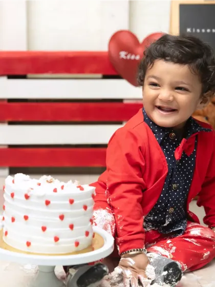 A happy, messy moment from a Valentine's cakesmash. The combination of the smart outfit and the fun of smashing cake creates unforgettable photos.