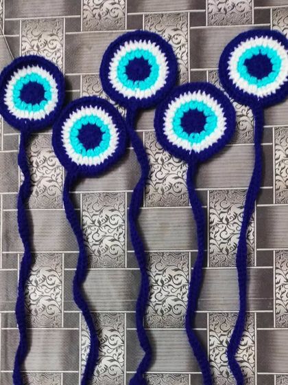 These are my evil eye bookmarks. They are made with dark blue, light blue, and white yarn. They are a very popular design and are great for keeping your place in a book. 🧿