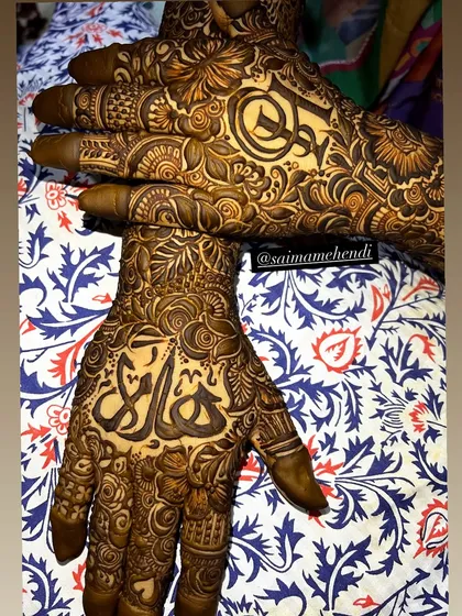 A stunning example of mirrored custom designs, with a name on one palm and an initial on the other, both executed with flawless symmetry.