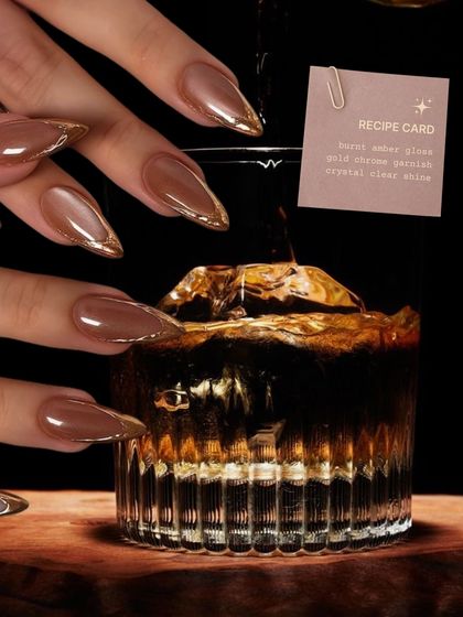 Inspired by a classic cocktail, these "Burnt Amber" nails feature a warm brown base with a gold chrome French tip, creating a rich and sophisticated look.
