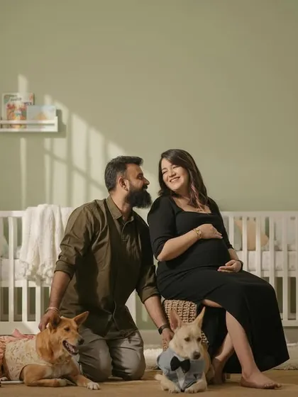 Your whole family is welcome, even the furry members! This is a heartwarming family maternity portrait in my studio's nursery setup, complete with a crib and soft, natural lighting.