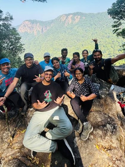 A happy group photo on the rocks, with the dense forests of Agumbe behind them.