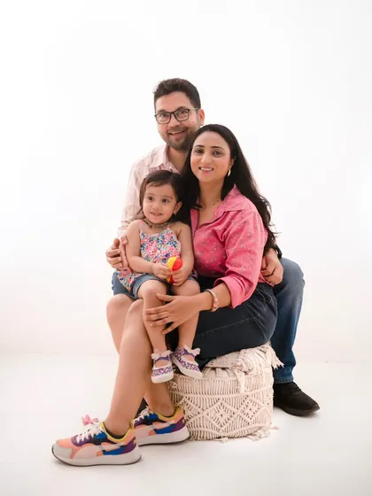 A relaxed and happy family portrait. Dressed in casual, colorful attire, this family's comfortable interaction is the highlight of this shot against a minimalist white background.