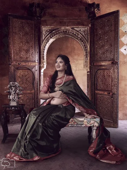 A regal portrait of a mama-to-be seated in an ornate, traditional setting. The bare bump adds a modern touch to the classic style.