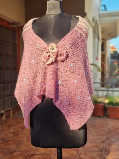 The full view of the knitted shrug on a mannequin. The asymmetrical shape and V-neck create a very flattering silhouette.