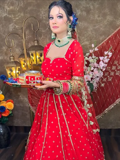 This full-length view shows how the red lehenga flows. It's a perfect choice for festivals, with a sweetheart neckline and elegant gold embroidery on the sleeves.