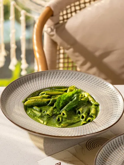 A vibrant penne pesto, where the bright green color of the sauce is the hero.
