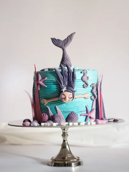 I had so much fun creating my version of the popular swimming mermaid cake. This under the sea theme cake features a hand-sculpted mermaid, complete with shimmering scales and surrounded by little seahorses, starfish, and shells. It's perfect for a magical birthday party.