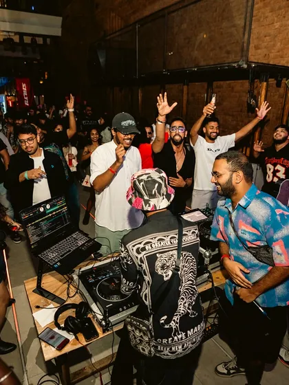 A wide shot showing the crowd gathered around the DJ booth. I love it when the party gets up close and personal.