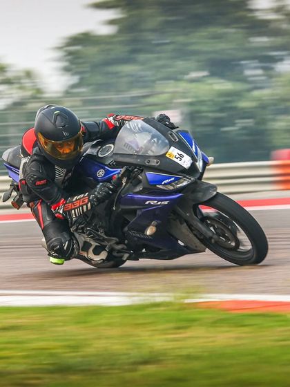 A rider on a Yamaha R15 tackles the famous parabola at the Buddh International Circuit, a corner that demands skill and bravery.