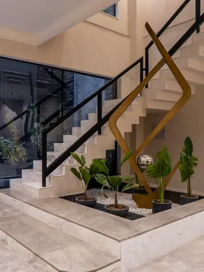 This staircase is a sculptural element in itself. I designed a small indoor garden at its base, bringing a touch of nature inside and turning a functional element into a beautiful feature.
