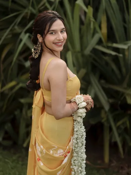 A profile shot of the bride, highlighting her elegant hairstyle and earrings for the Haldi ceremony.