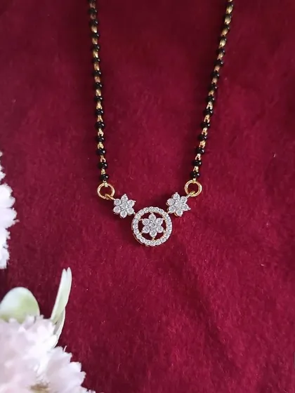 This 92.5 silver gold-plated mangalsutra has a delicate floral pendant. The design is simple yet elegant, making it suitable for daily wear.
