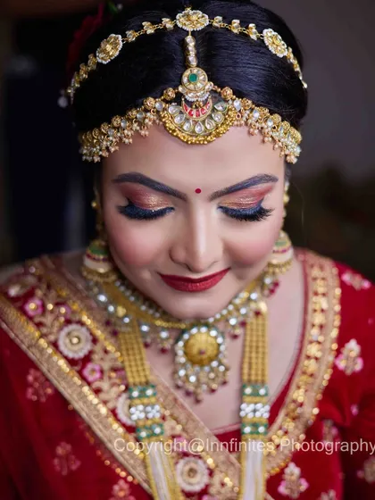 This portrait is all about the details. The focus is on the bride's stunning matha patti and necklace, highlighting the craftsmanship of her bridal jewelry.