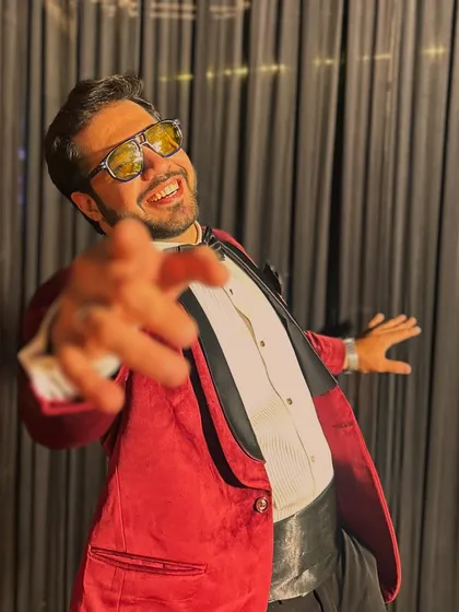 Reaching out to pull you into my happy world. This playful shot in my red tuxedo shows the fun-loving side I bring to every party.