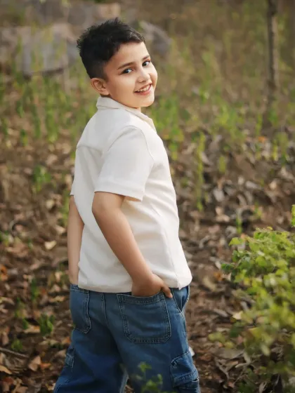 This is what a candid child portrait is all about. A natural, relaxed moment during an outdoor walk, capturing a genuine smile and the carefree spirit of childhood.