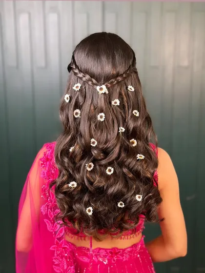 A back view of this beautiful floral mehendi hairstyle. The small, daisy-like flowers add a touch of freshness and fun, perfect for a daytime celebration.