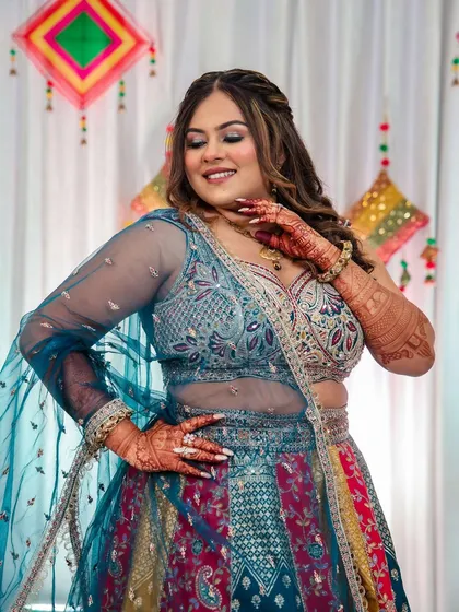 This bride is twirling with joy at her Samurta ceremony. Her makeup features a soft glam eye and a flawless base that enhances her natural beauty, letting her colorful outfit shine.