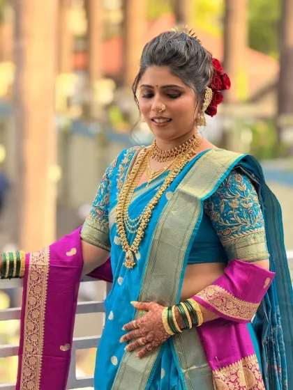 A beautiful shot of the bride on a balcony, showcasing her full look including the perfectly draped nauvari saree.